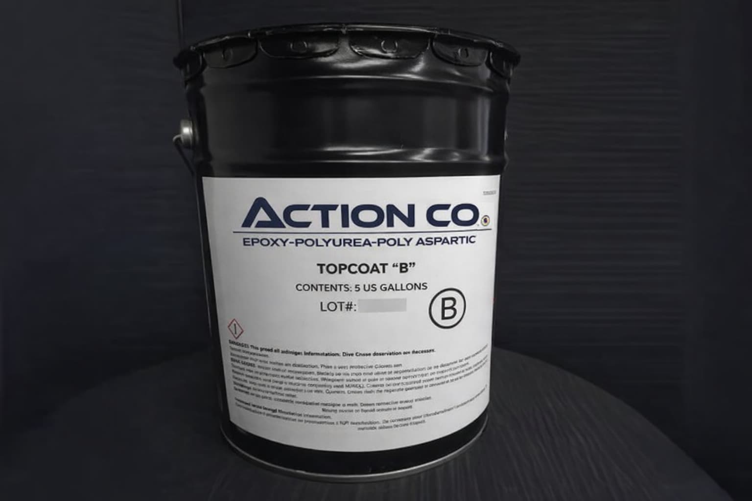 Action Co epoxy-polyurea-polyaspartic topcoat B in a 5-gallon black bucket with product label visible.